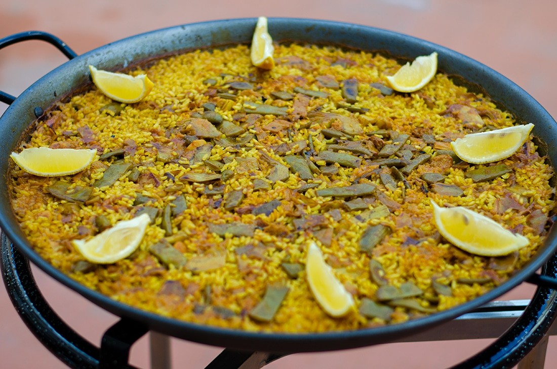 Paella with lemon wedges around the edges